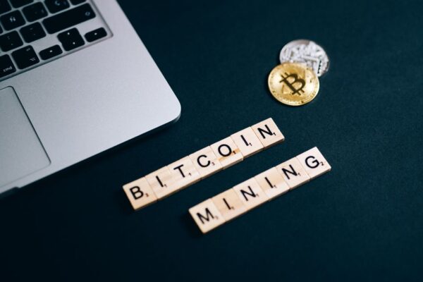 Top view of Bitcoin mining concept represented with laptop keyboard and Scrabble tiles.