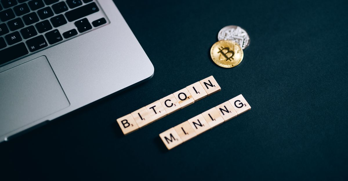 Top view of Bitcoin mining concept represented with laptop keyboard and Scrabble tiles.