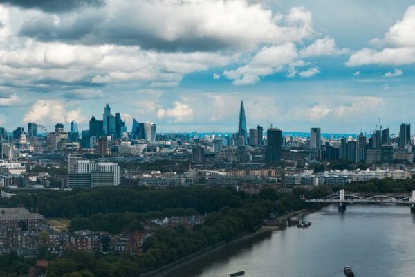 Wide-angle view of London's modern skyline and River Thames under a dramatic sky.