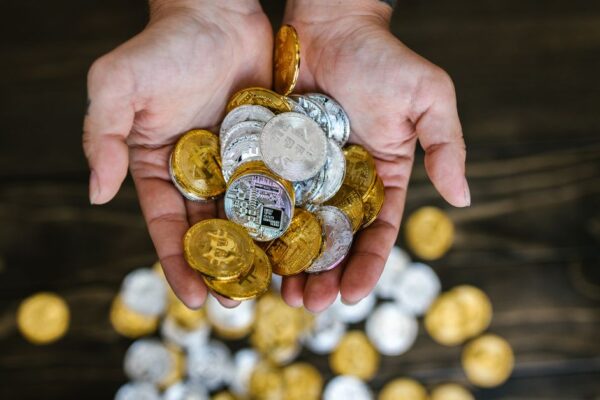 Close-up of hands holding gold and silver cryptocurrency coins symbolizing wealth and finance.