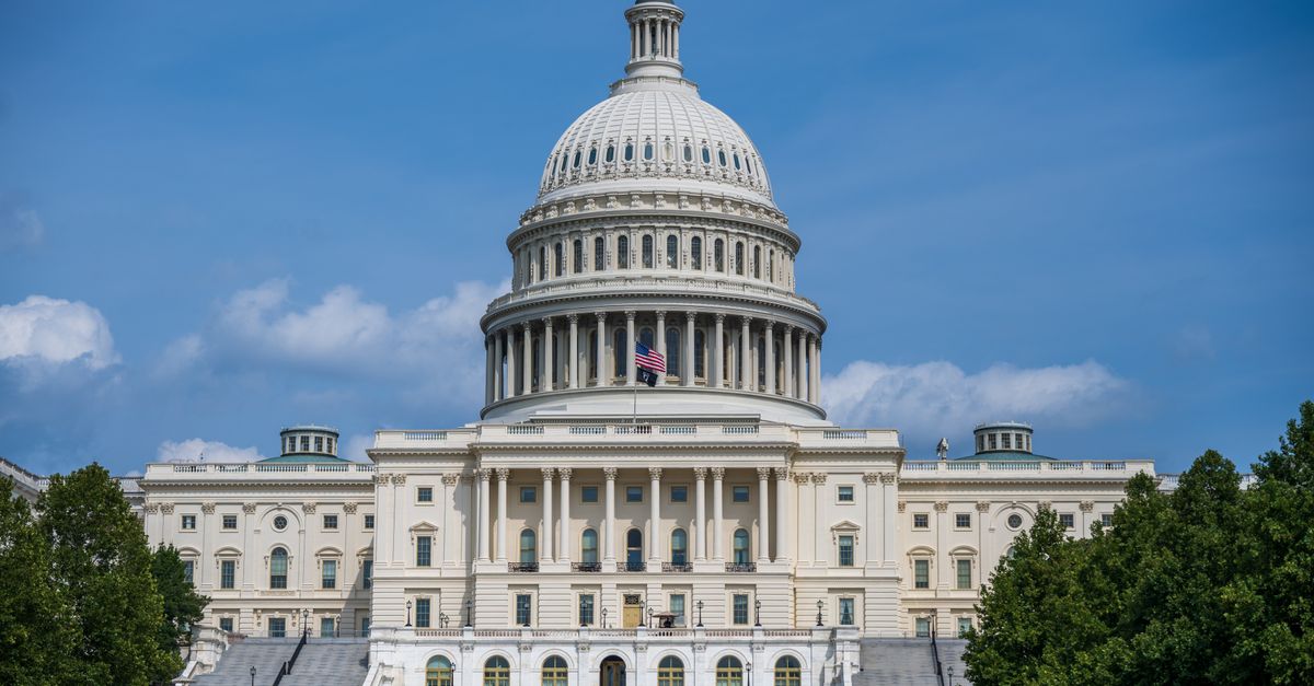 A frontal view of the iconic US Capitol Building in Washington D.C. under blue skies.