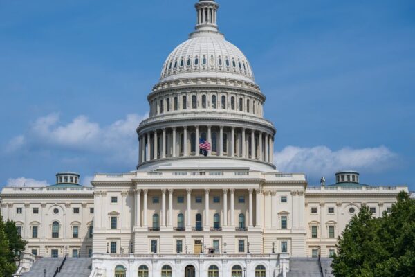 A frontal view of the iconic US Capitol Building in Washington D.C. under blue skies.