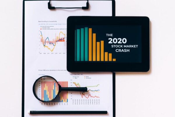 Tablet and clipboard with charts illustrating the 2020 stock market crash.