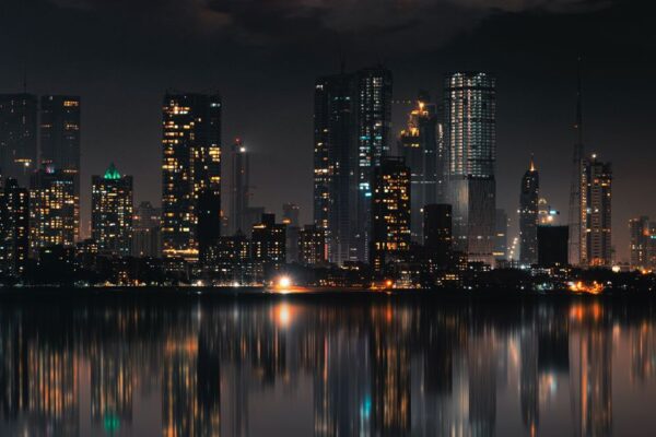 Captivating night view of Mumbai skyline with skyscrapers and reflections on still water.