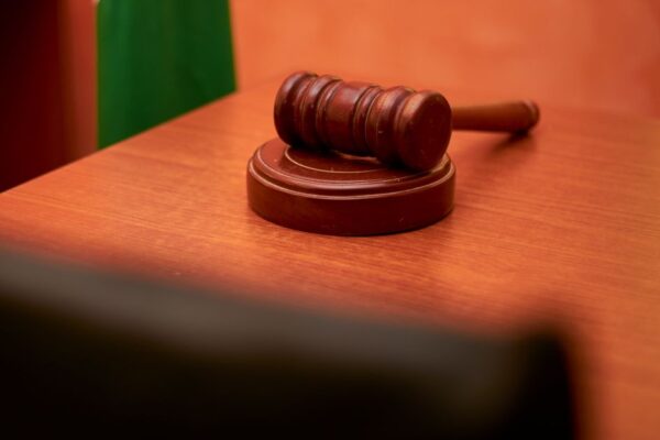 A close-up of a gavel on a courtroom desk representing law and justice.