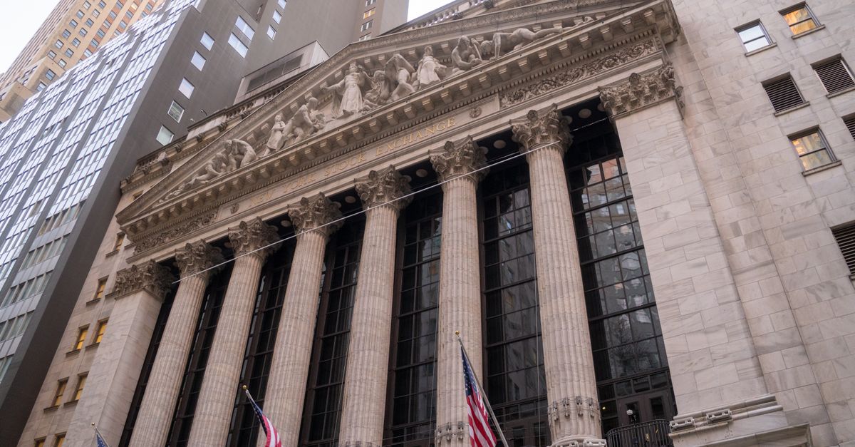 Close-up view of the iconic New York Stock Exchange building with American flags, located in Wall Street, NYC.