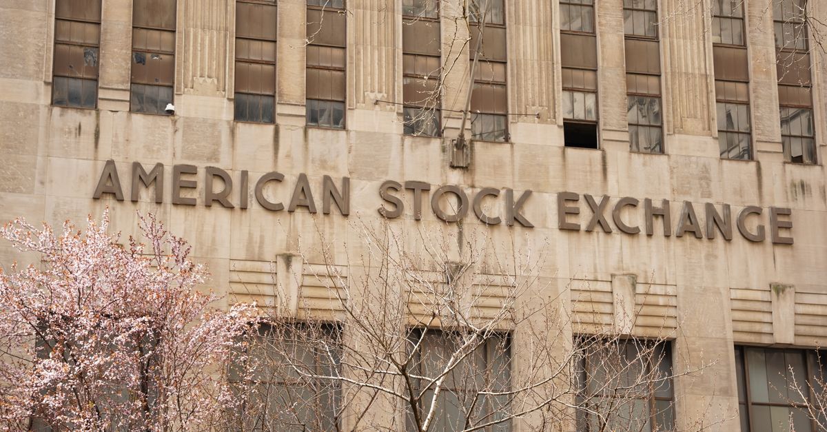 Facade of the American Stock Exchange Building in New York City during spring with blooming trees.